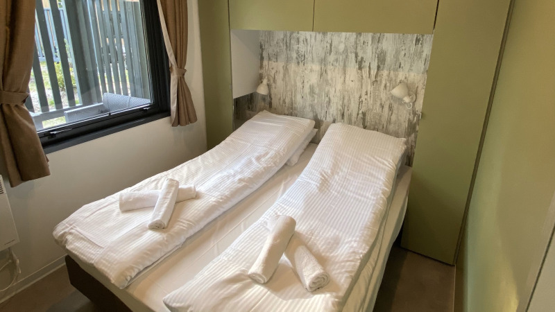 Dormitorio en Cottage Next XXL Family Deluxe en Papillon Country Resort con dos camas individuales y ventana.