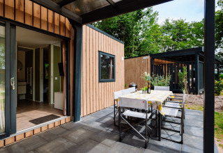 Buitenterras met eettafel bij Cottage Next XXL Family Deluxe op Papillon Country Resort, Nederland