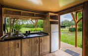 Cocina moderna en Air Dreamer 3 Deluxe en Papillon Country Resort, Países Bajos, con vistas a la naturaleza.