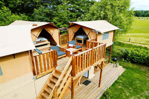 Air Dreamer 3 Deluxe lodge aan Papillon Country Resort in Nederland met houten terras en tenten.