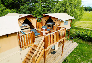 Air Dreamer 3 Deluxe lodge aan Papillon Country Resort in Nederland met houten terras en tenten.