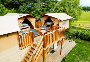 Lodge Air Dreamer 3 Deluxe bij Papillon Country Resort in Nederland met houten terras en tenten.