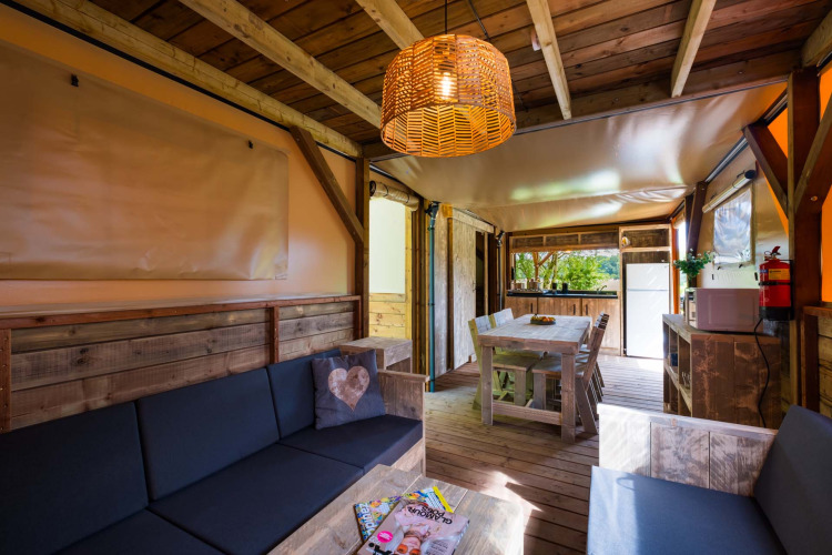 Interior de madera del lodge Air Dreamer 3 Deluxe en Papillon Country Resort, Países Bajos, con comedor.