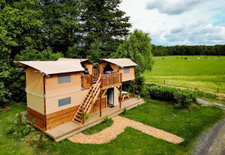 Vista aérea del lodge Air Dreamer 3 Deluxe en Papillon Country Resort en los Países Bajos, junto a un campo verde.