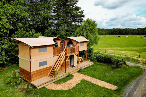 Luftaufnahme der Air Dreamer 3 Deluxe Lodge im Papillon Country Resort in den Niederlanden neben Weiden.