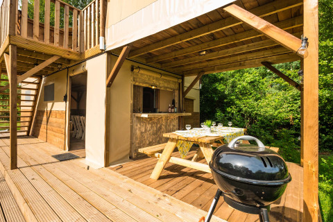 Außenbereich der Air Dreamer 3 Deluxe-Lodge im Papillon Country Resort in den Niederlanden, mit Grill und Sitzbank.