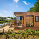 Moderne Fish Cabin Deluxe lodge ved søen på Papillon Country Resort i Holland med stor træterrasse.