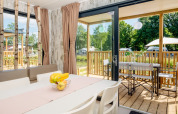 Moderne Fish Cabin Deluxe lodge met eethoek en terras op Papillon Country Resort in Nederland.