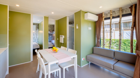 Licht en modern interieur van Fish Cabin Deluxe in Papillon Country Resort, Nederland, met eethoek en zetel.