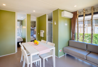 Licht en modern interieur van Fish Cabin Deluxe in Papillon Country Resort, Nederland, met eethoek en zetel.