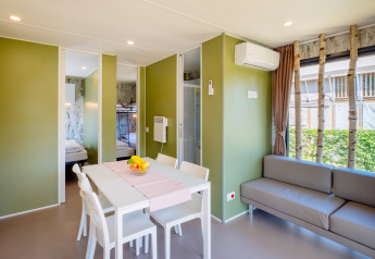 Licht en modern interieur van Fish Cabin Deluxe in Papillon Country Resort, Nederland, met eethoek en zetel.