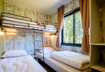 Værelse i Fish Cabin Deluxe på Papillon Country Resort med køjeseng, enkeltsenge og stort vindue.