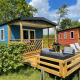 Udendørs terrasse ved Fish Cabin lodgen på Papillon Country Resort, med moderne blå og rød hytter.