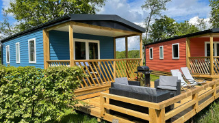 Udendørs terrasse ved Fish Cabin lodgen på Papillon Country Resort, med moderne blå og rød hytter.