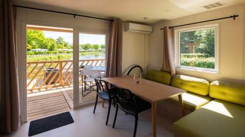Interieur van een Fish Cabin-lodge bij Papillon Country Resort in Nederland met uitzicht op het meer en terras.