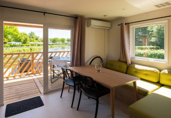 Interno di una Fish Cabin al Papillon Country Resort nei Paesi Bassi, con vista su lago e terrazza.