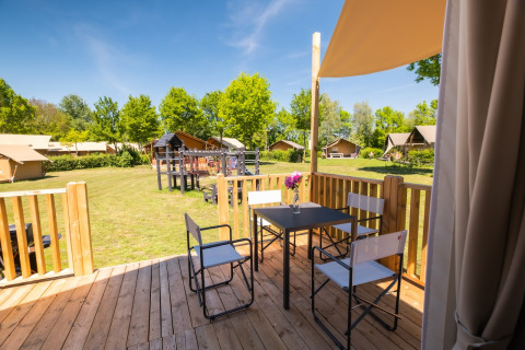 Uitzicht vanaf het houten terras met tafel en stoelen bij Air Lodge 2.0, Papillon Country Resort, Nederland.
