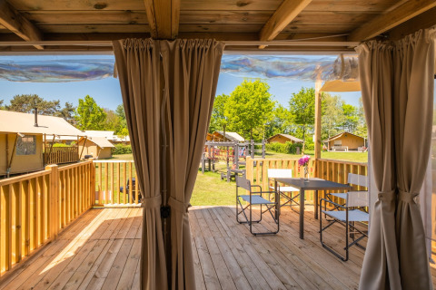 Houten terras met tafel en stoelen bij Air Lodge 2.0 op Papillon Country Resort, Nederland, zonnige dag.