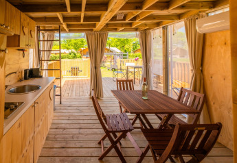 Binnenzicht van Air Lodge 2.0 aan Papillon Country Resort, Nederland, met houten meubels en eethoek.