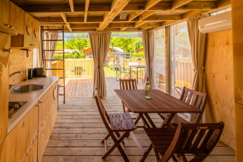 Binnenzicht van Air Lodge 2.0 aan Papillon Country Resort, Nederland, met houten meubels en eethoek.