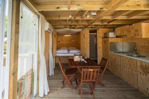 Interieur van Air Lodge 2.0 bij Papillon Country Resort, met houten inrichting en knusse eethoek.