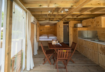 Binnenzicht van Air Lodge 2.0 op Papillon Country Resort, met houten interieur en gezellige eethoek.