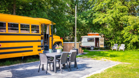 Vista exterior del lodge Schoolbus Papillon y caravana con zona de asientos en Papillon Country Resort.
