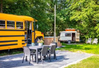 Außenansicht der Schoolbus Papillon Lodge und Wohnwagen mit Sitzbereich im Papillon Country Resort.