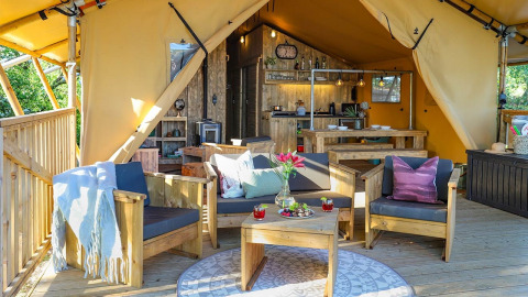 Acogedor interior de la Safari tent Premium en Papillon Country Resort, Países Bajos, con muebles de madera.