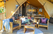 Acogedor interior de la Safari tent Premium en Papillon Country Resort, Países Bajos, con muebles de madera.