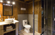 Baño del safari-tienda Spotty Lodge Family en Papillon Country Resort, Países Bajos, con paredes de madera y ducha moderna.