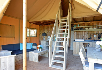 Intérieur de la tente safari Spotty Lodge Family au Papillon Country Resort aux Pays-Bas, mobilier en bois.