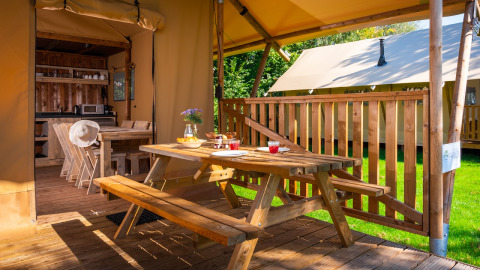 Buiten eetruimte en binnenkeuken van een safaritent bij Papillon Country Resort in Nederland.