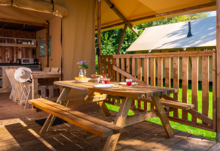 Outdoor dining area and inside kitchen of a safari tent at Papillon Country Resort in the Netherlands.