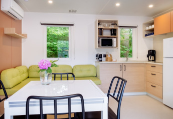 Moderne køkken og spiseområde i Cottage Next XXL Family på Papillon Country Resort, Holland, med udsigt over naturen.