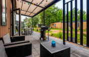 Overdekt terras met tuinmeubilair en barbecue aan Cottage Next XXL Family, Papillon Country Resort, Nederland.