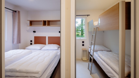 Slaapkamers in Cottage Next XXL Family bij Papillon Country Resort, Nederland, met dubbel- en stapelbed.
