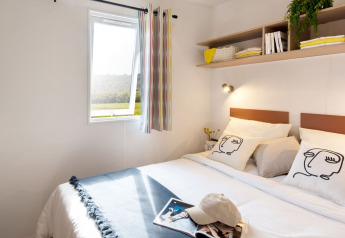 Lichte slaapkamer in Cottage Next XXL Family op Papillon Country Resort, met moderne decoratie en open raam.