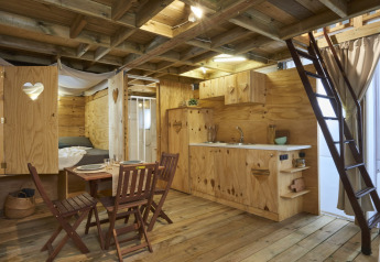 Vue intérieure de l’Airlodge 2.0 Family Hottub au Papillon Country Resort, Pays-Bas, avec mobilier en bois rustique.