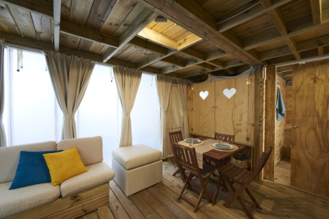 Vista interior del Airlodge 2.0 Family Hottub en Papillon Country Resort con decoración de madera y mesa comedor.