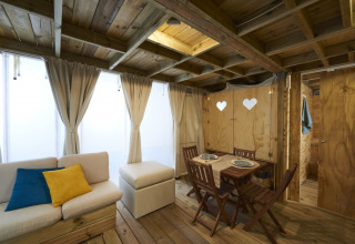 Vista interior del Airlodge 2.0 Family Hottub en Papillon Country Resort con decoración de madera y mesa comedor.