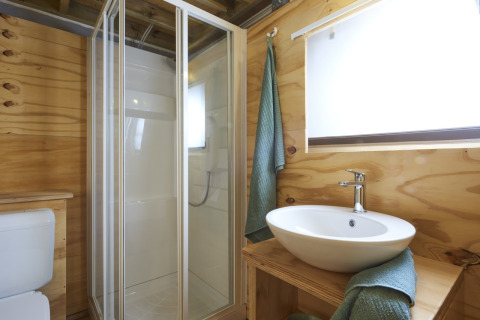 Baño moderno con ducha, lavabo y paredes de madera en Airlodge 2.0 Family Hottub, Papillon Country Resort, Países Bajos.