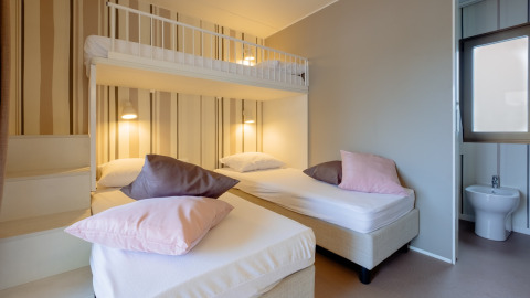Modern ingerichte slaapkamer met stapelbed en enkele bedden in Cottage Next XL Luxury Superior, Papillon Country Resort.