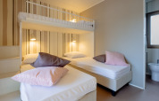 Modern ingerichte slaapkamer met stapelbed en enkele bedden in Cottage Next XL Luxury Superior, Papillon Country Resort.