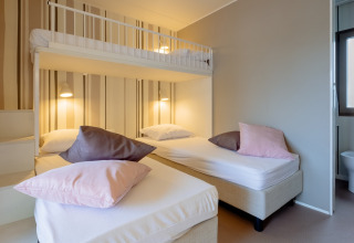 Dormitorio moderno con camas individuales y litera en Cottage Next XL Luxury Superior, Papillon Country Resort.