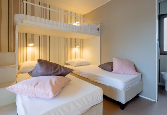 Modern ingerichte slaapkamer met stapelbed en enkele bedden in Cottage Next XL Luxury Superior, Papillon Country Resort.