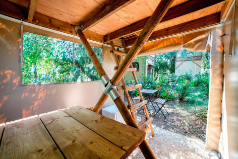 Intérieur d'une tiny house Airstay au Papillon Country Resort, avec mobilier en bois et vue sur jardin.