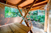 Binnenzicht van een Airstay tiny house bij Papillon Country Resort, met houten tafels en tuin buiten.