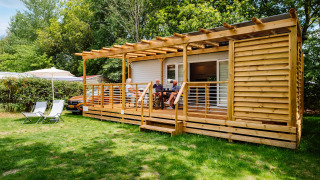 Cottage Next Midi lodge aan Papillon Country Resort in Nederland, mensen op de houten veranda buiten.