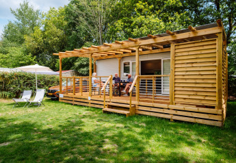 Cottage Next Midi lodge aan Papillon Country Resort in Nederland, mensen op de houten veranda buiten.